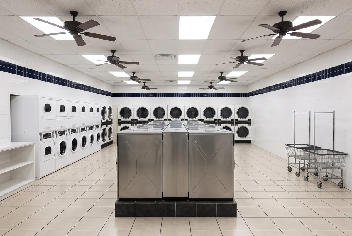 Stainless steel washers and stacked dryers inside Smile Laundromat